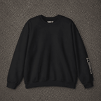 A black crewneck sweatshirt with white graphic text on the inner neck and left sleeve, laid flat on a dark gray asphalt background.
