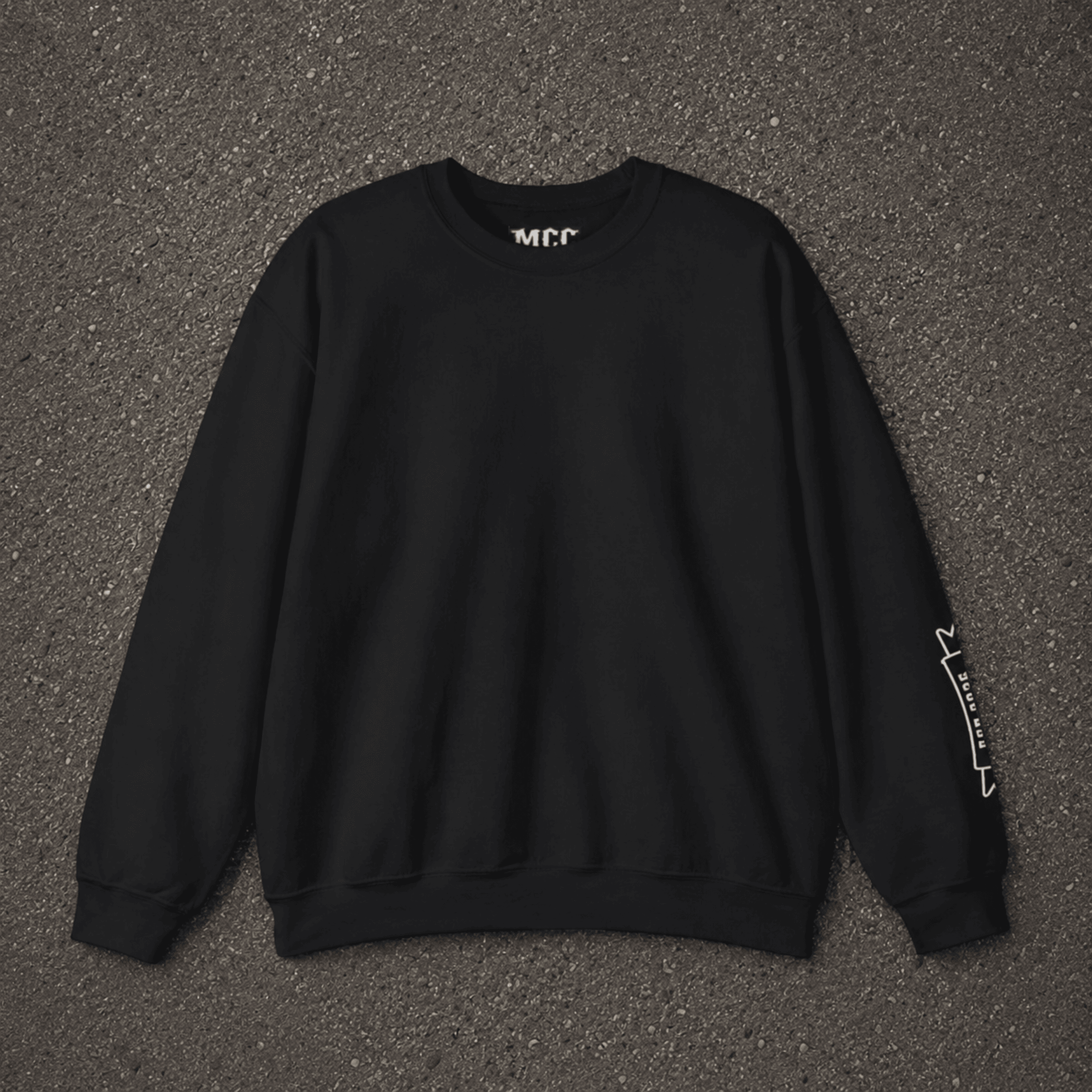 A black crewneck sweatshirt with white graphic text on the inner neck and left sleeve, laid flat on a dark gray asphalt background.